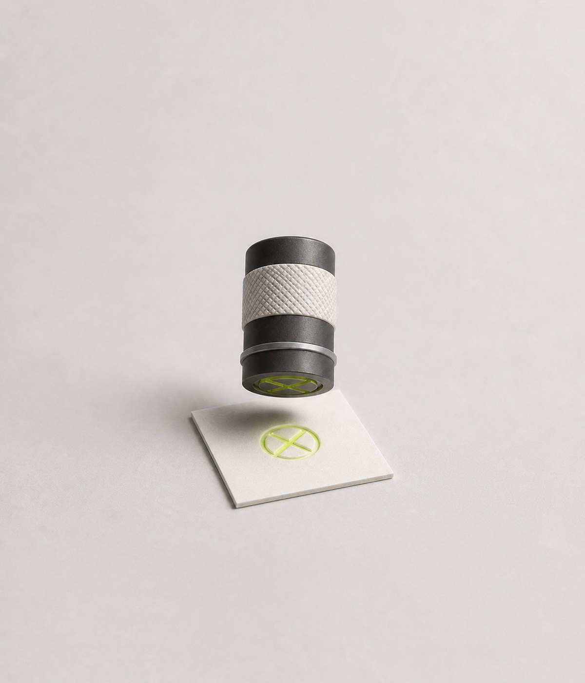 A miniature approval stamp suspended above a blank card.
